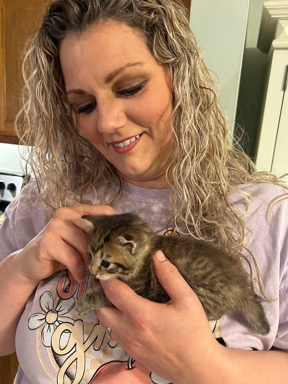 A happy owner holding her new kitten.